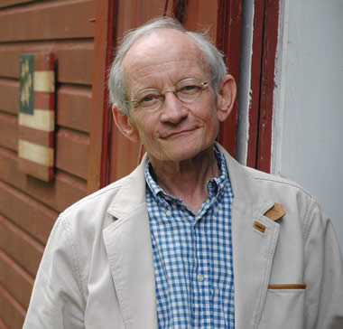 Ted Kooser smiling outside of a house